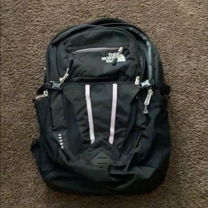 Black and pinkish purple northface backpack